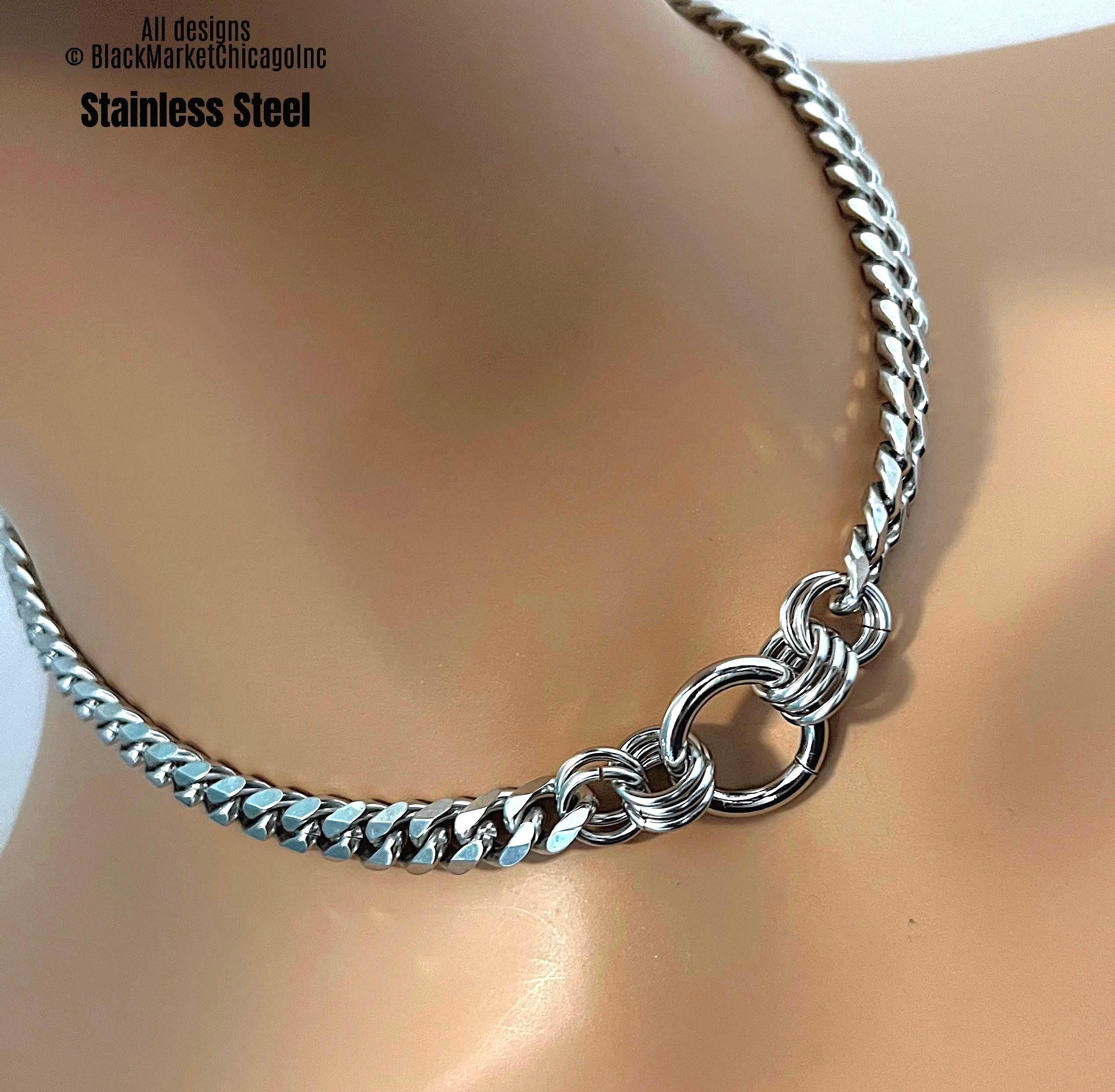 A discreet bdsm day collar; all shiny silver stainless steel; 8mm tight link curb chain with thick, 22mm center o-ring secured by 10 thick jump rings; waterproof, and permanent lock option.